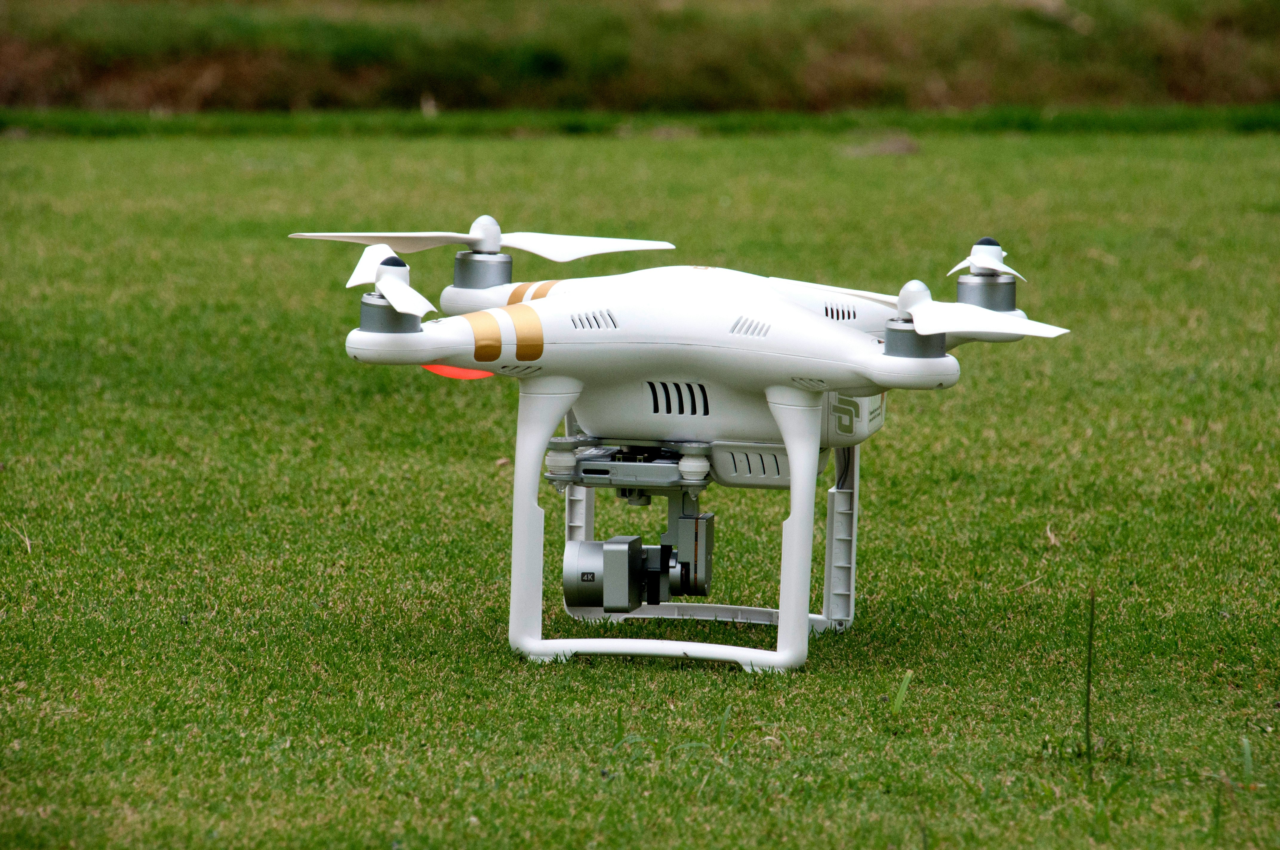 white quadcopter on lawn